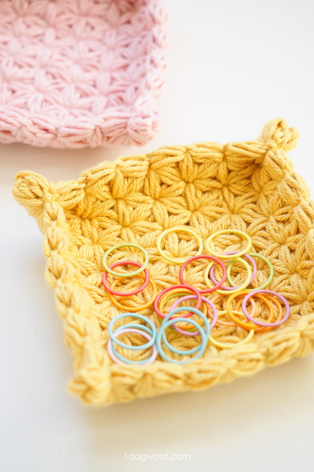 yellow crochet jewelry dish holding stitch markers