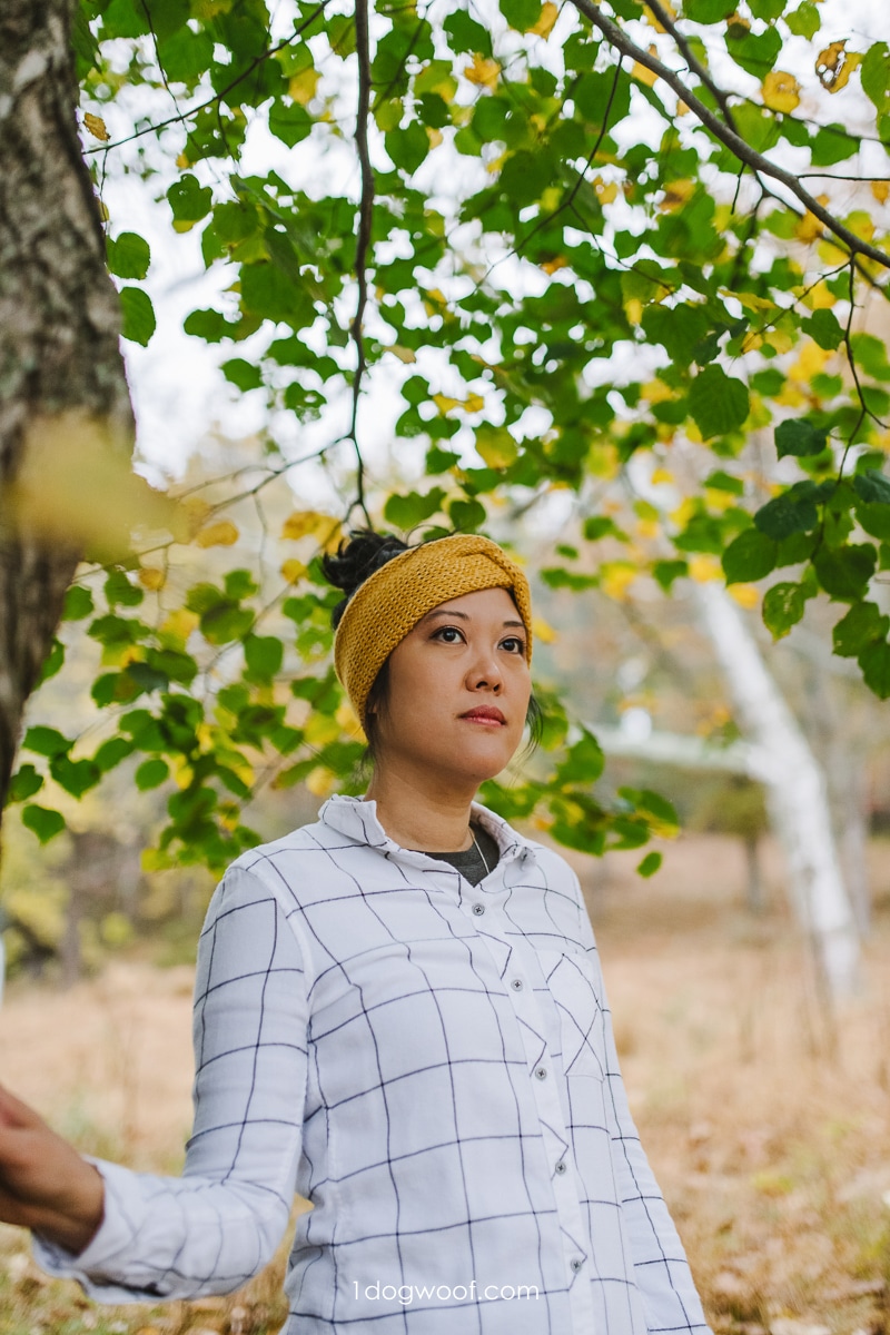 woman wearing mustard yellow ear warmer in fall woods